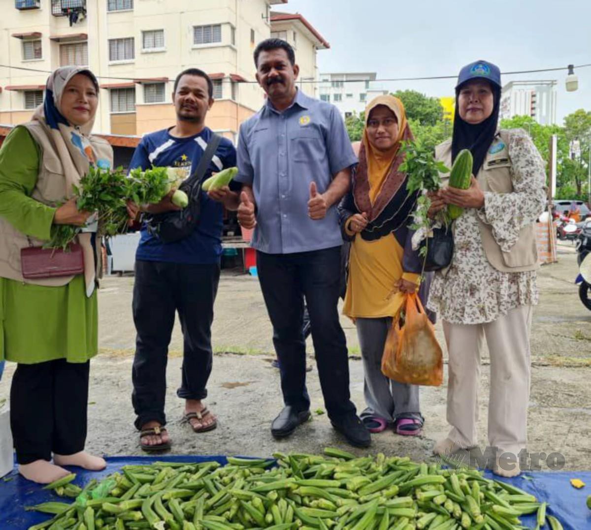 KANNAN (tengah) ketika pengagihan sayuran percuma membantu penduduk. FOTO Ihsan Datuk Dr Kannan Raman