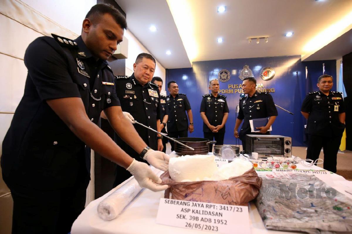 Khaw Kok Chin (dua dari kiri) menunjukkan plastik lutsinar berisi dadah jenis heroin anggaran berat 7,400 gram bernilai RM61,420 pada sidang media di Ibu Pejabat Kontinjen Pulau Pinang di sini hari ini. FOTO MIKAIL ONG