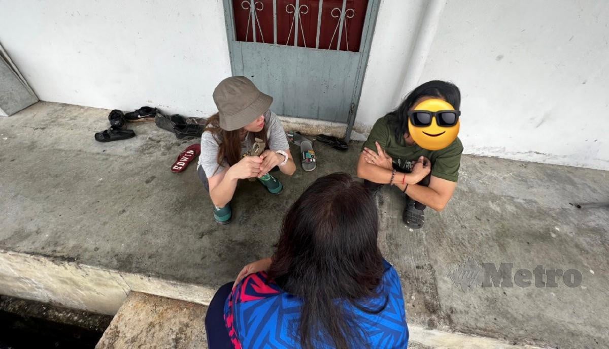 Marina (kiri) bersembang bersama wanita itu (kanan) yang menyimpan sampah di luar dan dalam rumahnya. FOTO Ihsan Marina Ibrahim
