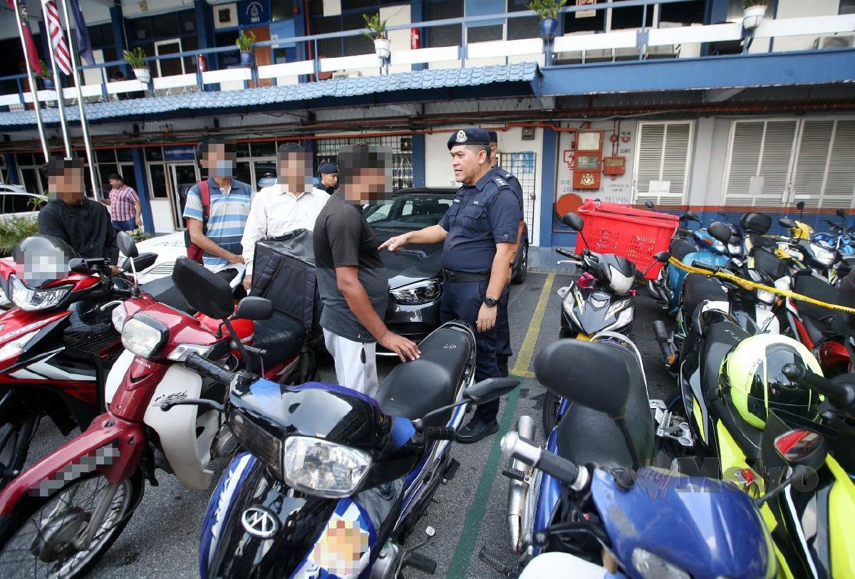 SARIFUDIN memberi nasihat kepada pengguna jalan raya yang ditahan sempena Operasi Hormat Undang-Undang Jalan Raya di sekitar Kuala Lumpur. FOTO Eizairi Shamsudin