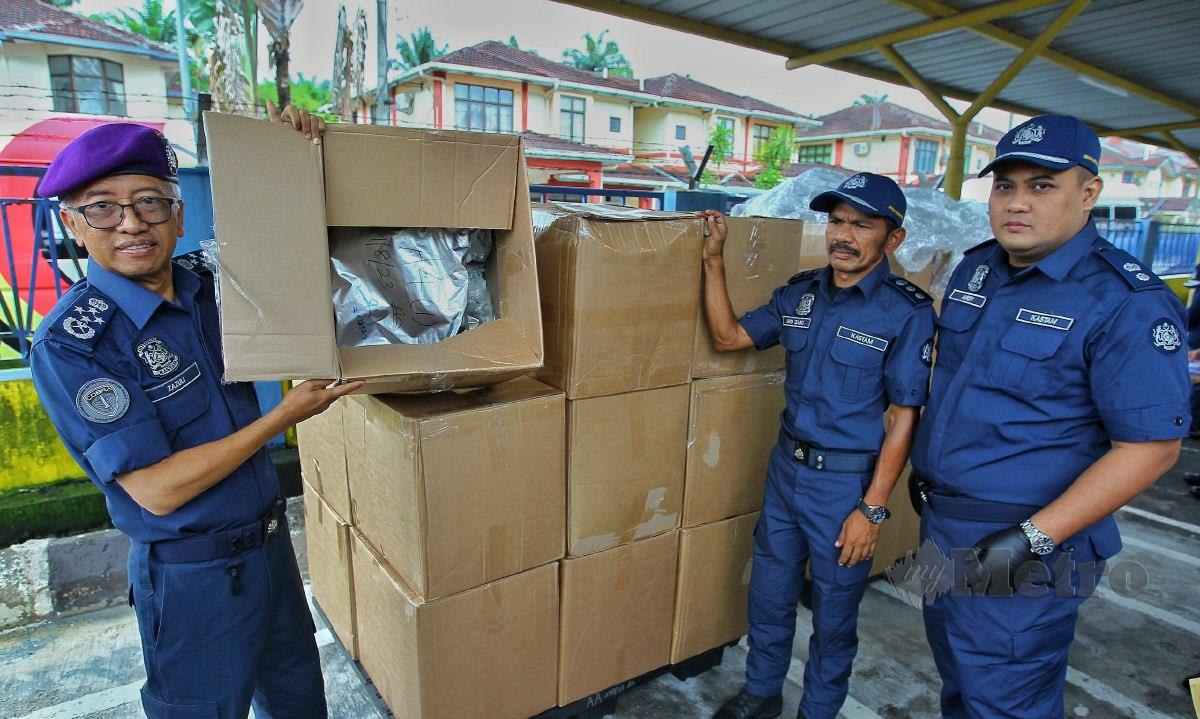 ZAZULI (kiri) menunjukkan kotak yang mengandungi dadah MDMA dianggarkan bernilai RM32 juta. FOTO Azrul Edham