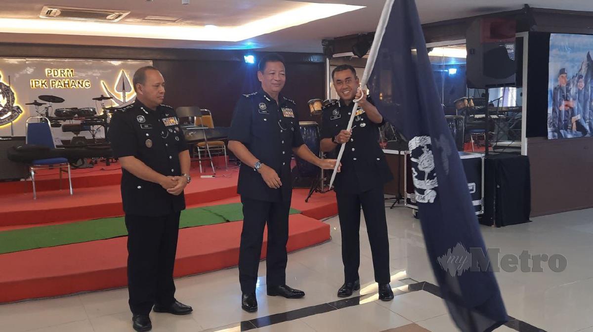 Yahaya Othman menyerahkan bendera PDRM kepada Ketua Jabatan Siasatan Jenayah Pahang, Datuk  Mohd Yusri Othman pada Majlis Pelepasan Dan Penyerahan Bendera Kontinjen Pahang sempena Ekspedisi Mendaki Gunung Kinabalu di Kuantan. FOTO Asrol Awang