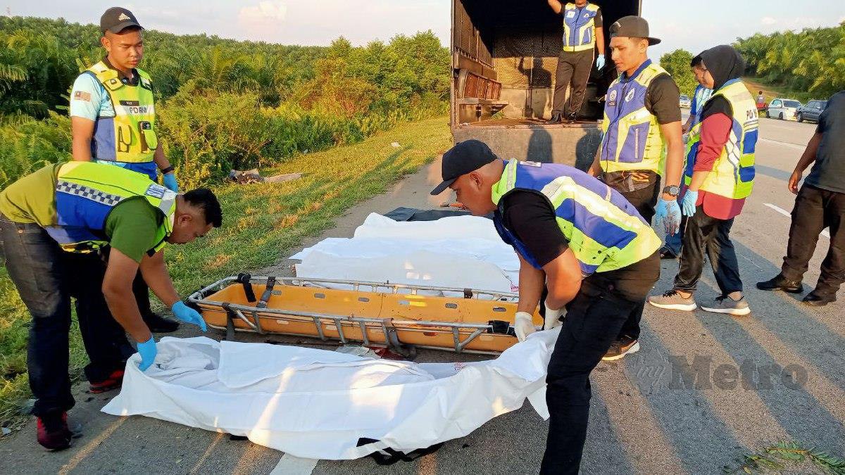 ANGGOTA polis mengangkat mayat tiga mangsa yang maut dalam nahas tiga kenderaan di KM 167 Jalan Johor Bahru- Seremban dekat Segamat petang tadi. FOTO Ahmad Ismail.