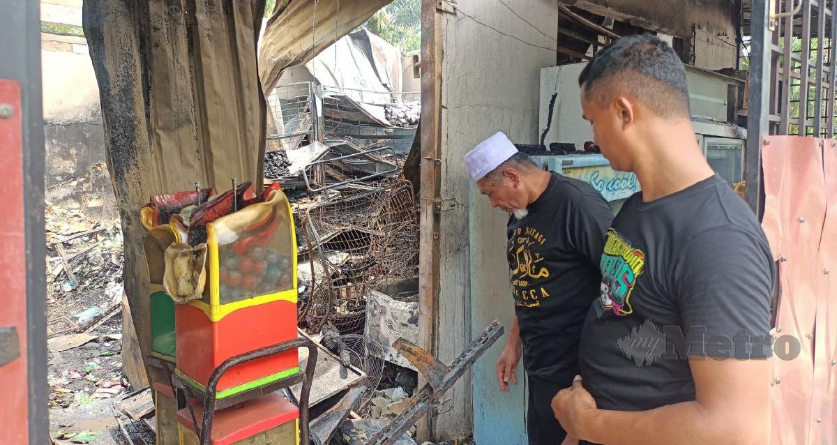 Pemilik kedai runcit, Safuan Mohd Nordin, 33, melihat keadaan premisnya yang musnah dalam kebakaran di Kampung Teliar, pagi tadi. FOTO SITI ROHANA IDRIS