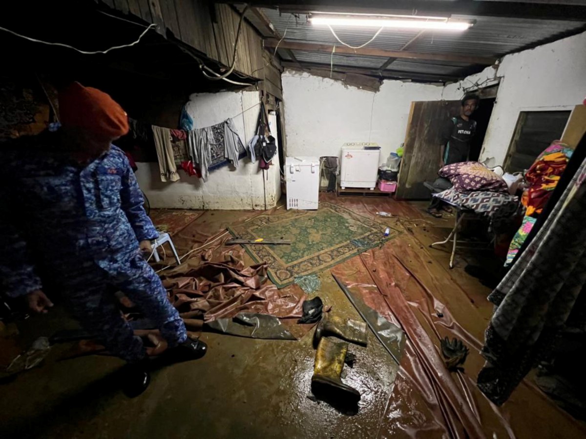 ANGGOTA APM meninjau rumah mangsa terjejas banjir kilat di Mukim Gurun. FOTO Ihsan APM.