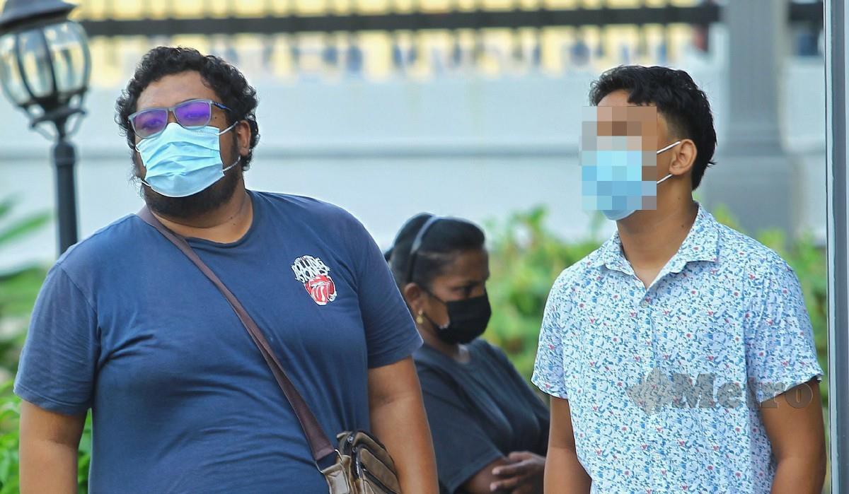MOHAMMAD Fahmi Azrai (kiri) dan adiknya (kanan) ketika hadir di Mahkamah Majistret Port Dickson. FOTO Azrul Edham