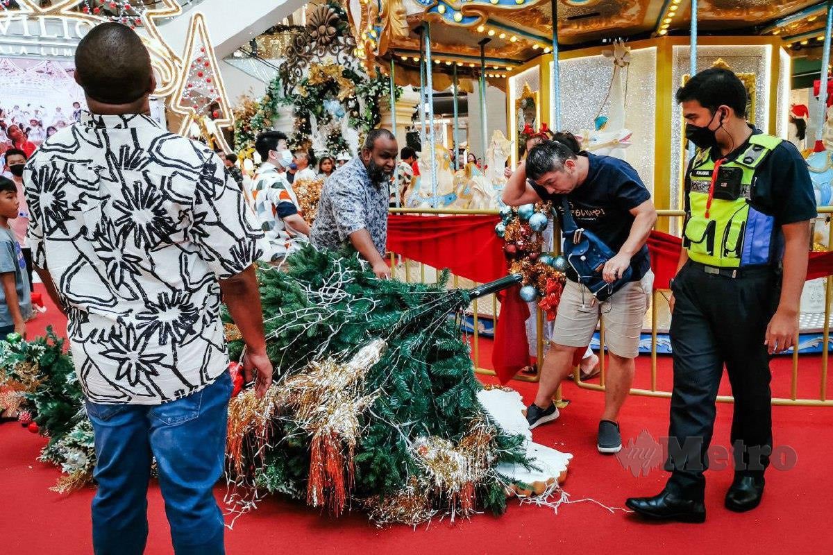 JULIUS (dua dari kanan) dihempap pokok perhiasan Krismas yang terjatuh di sebuah pusat beli-belah. FOTO Asyraf Hamzah