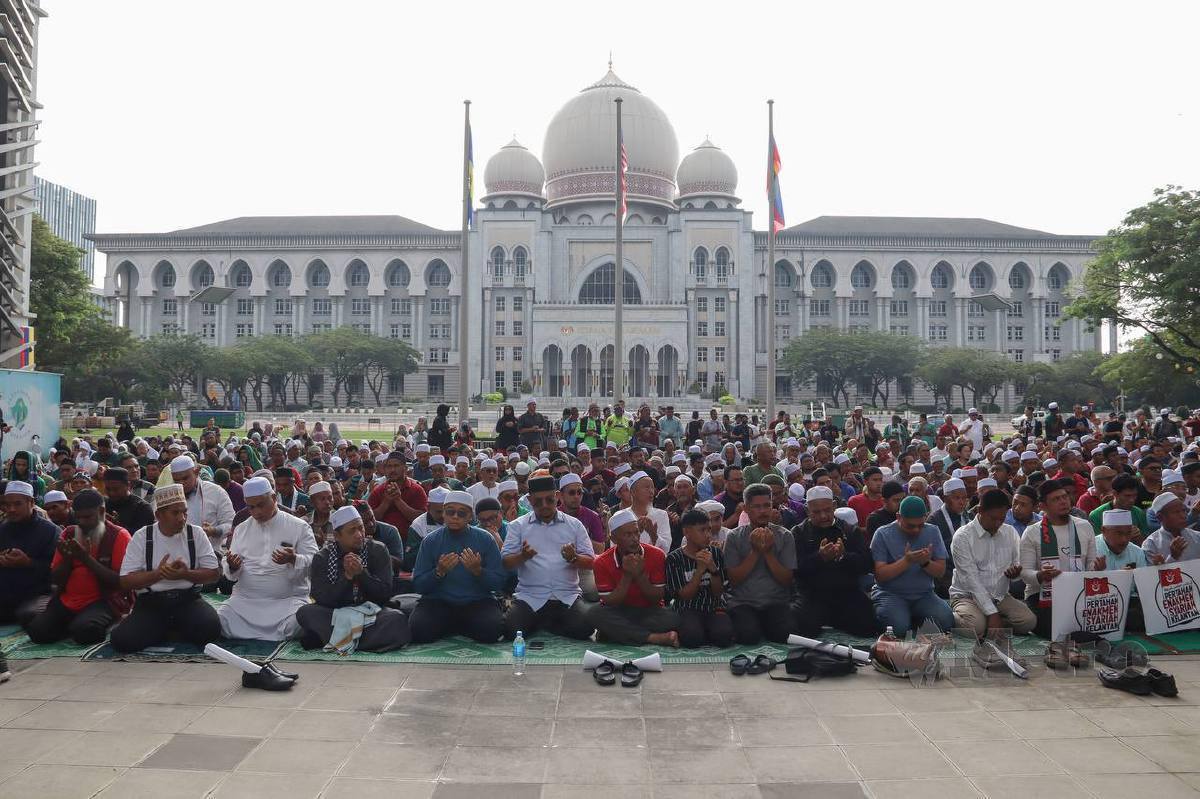 PESERTA Himpunan Selamatkan Syariah anjuran Gerakan Pembela Ummah (UMMAH) menunaikan solat di perkarangan Perbadanan Putrajaya. FOTO Aiman Danial