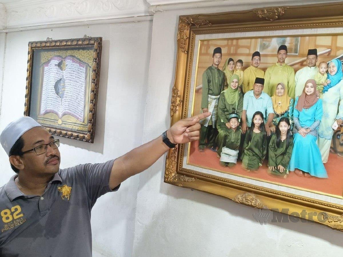 ABDUL Latif menunjukkan gambar kenangan keluarga bersama arwah adiknya, Noor Rahiza. FOTO Zuliaty Zulkiffli