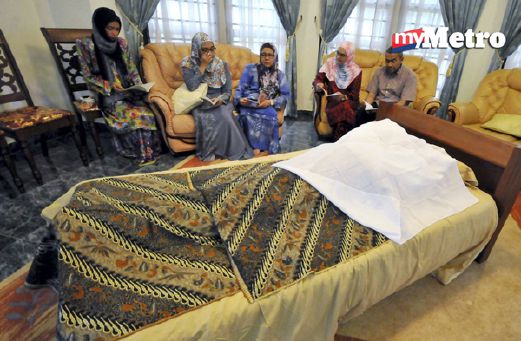 Isteri Datuk Seri Junus, Datin Insah Daharun (tiga dari kiri) bersama anaknya membaca surah Yasin sementara menunggu jenazah bekas Speaker Dewan Undangan Negeri (DUN) Perak dimandikan serta dikafankan. - Foto MOHD NAZRULASWAD.