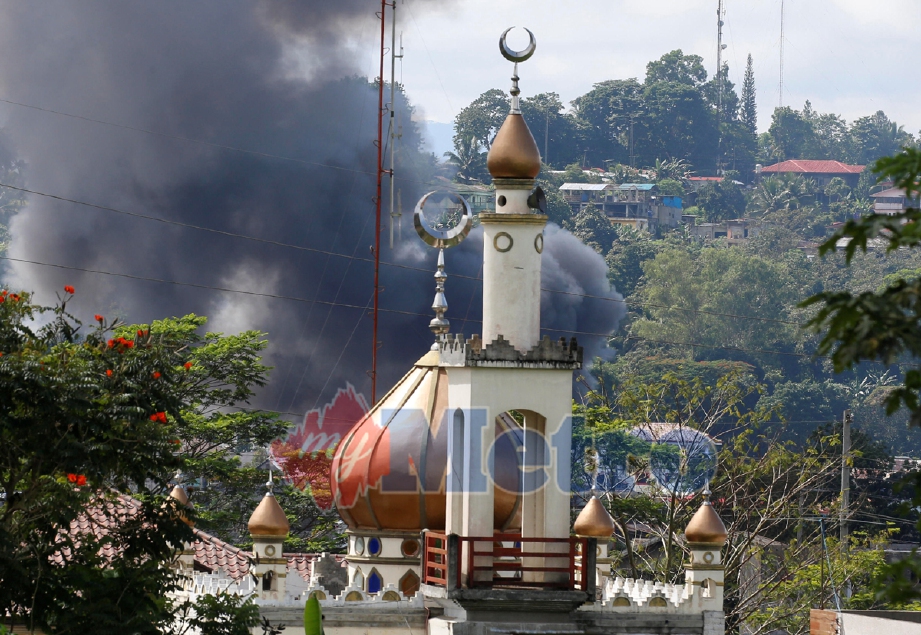 Kepulan asap dari kawasan pertempuran dekat sebuah masjid di Marawi. - Foto REUTERS