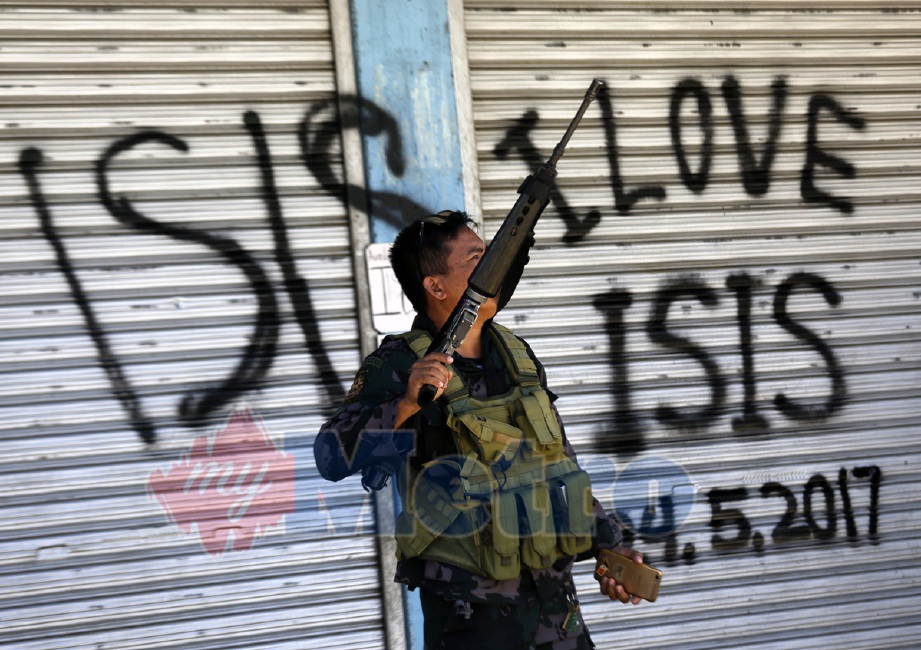 Tulisan memuji Negara Islam (IS) yang diconteng pada pintu bangunan di Marawi. - Foto EPA