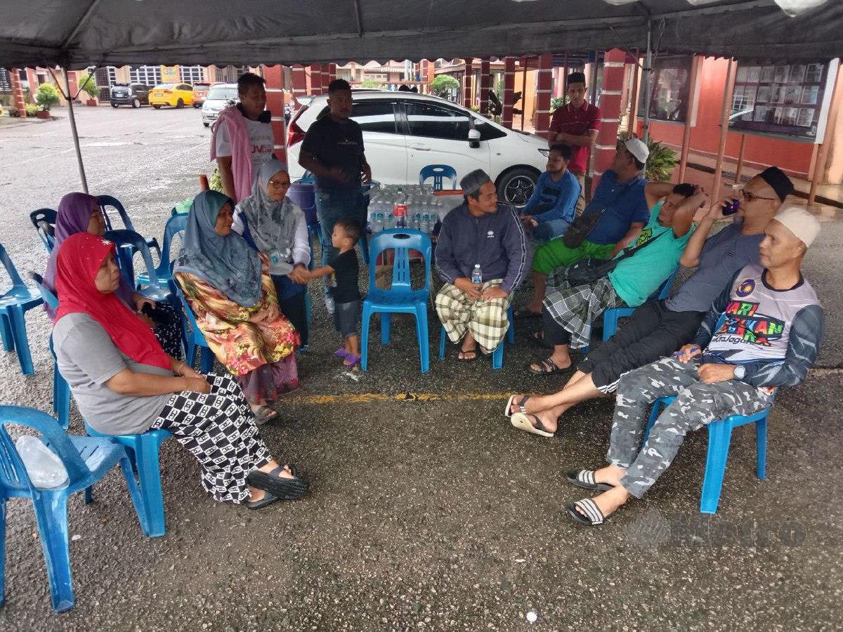Ab Azih (duduk kanan) bersama sebahagian penduduk Kampung Paya Besar, ketika ditemui di Pusat Pemindahan Sementara SK Kuala Berang. FOTO NAZDY HARUN