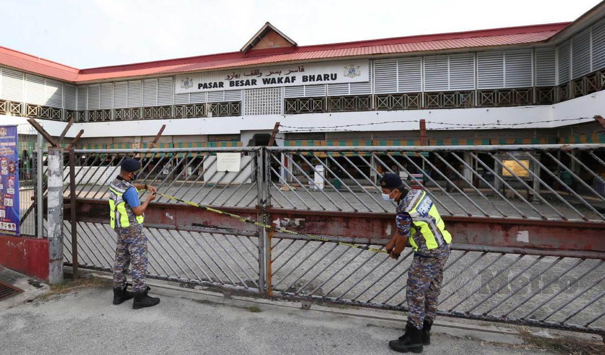 ANGGOTA Majlis Daerah Tumpat meletakkan notis penutupan Pasar Besar Wakaf Bharu. FOTO Nik Abdullah Nik Omar