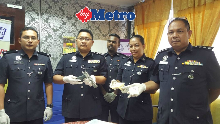 Ketua Polis Daerah Langkawi, Asisten Komisioner Polis Dr Che Ghazali Che Awang (dua dari kiri) menunjukkan pistol jenis Browning 9 mm automatik dan peluru hidup yang dirampas daripada seorang lelaki warga Thailand di Kampung Temonyong, Langkawi. FOTO Hamzah Osman