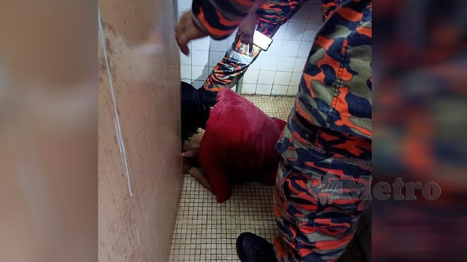 Anggota bomba sedang mengeluarkan kaki wanita OKU yang tersepit pada mangkuk tandas di Taman Sri Wang, Sungai Petani semalam. Foto Ihsan JBPM