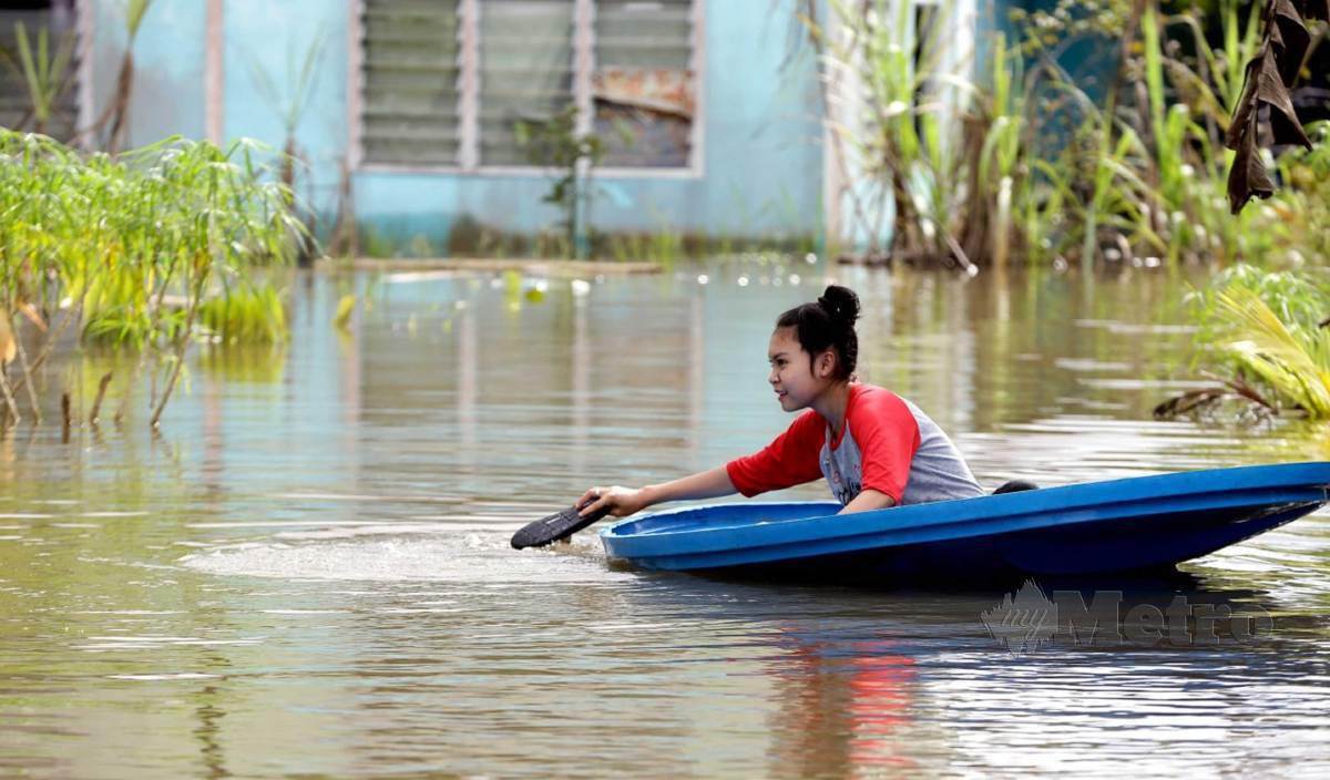 FOTO yang dirakamkan pada 17 Januari lalu menunjukkan  penduduk Kampung Tanah Puteh, Serian, Nursyafikah Najwa Ashry 15, meredah banjir. FOTO Nadim Bokhari