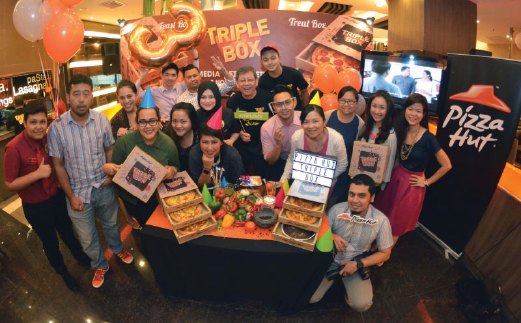 LOO (kiri) bersama kakitangan menunjukkan promosi terbaru Pizza Hut, Triple Box.