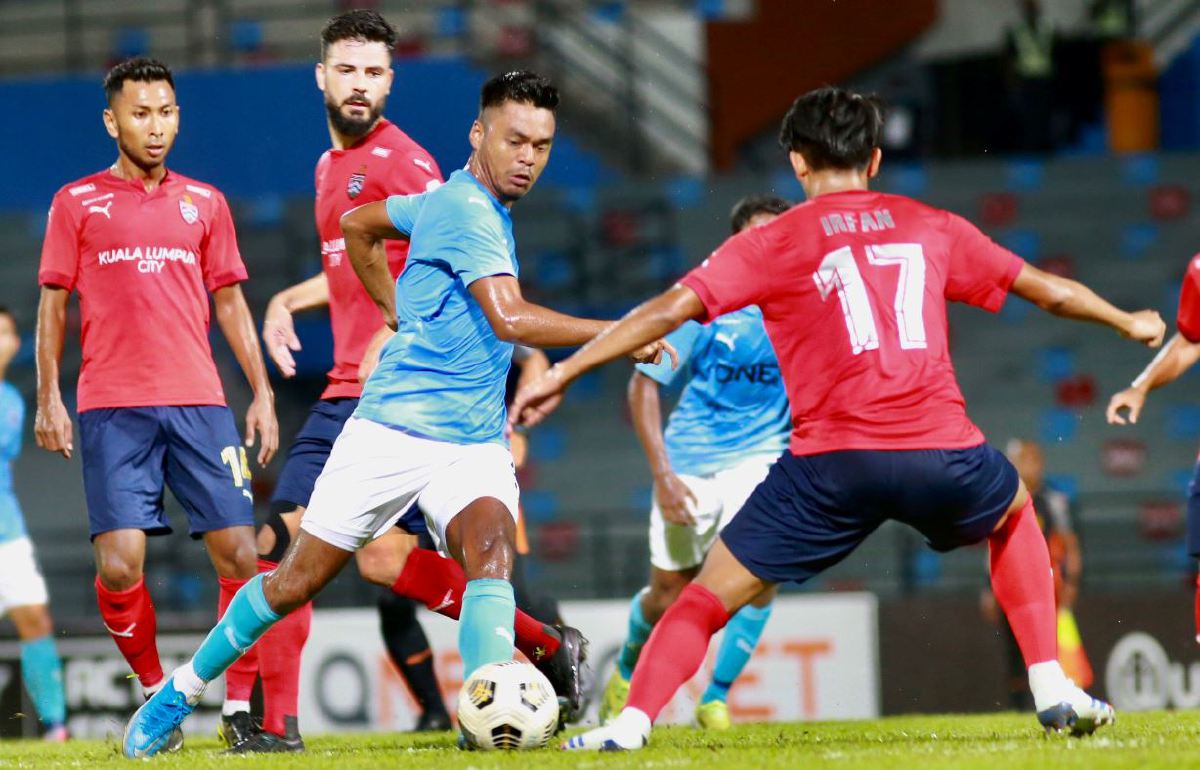 PEMAIN PJ City, Muhammad Faiz diasak pertahanan Kuala Lumpur di Stadium MBPJ. FOTO Fathil Asri
