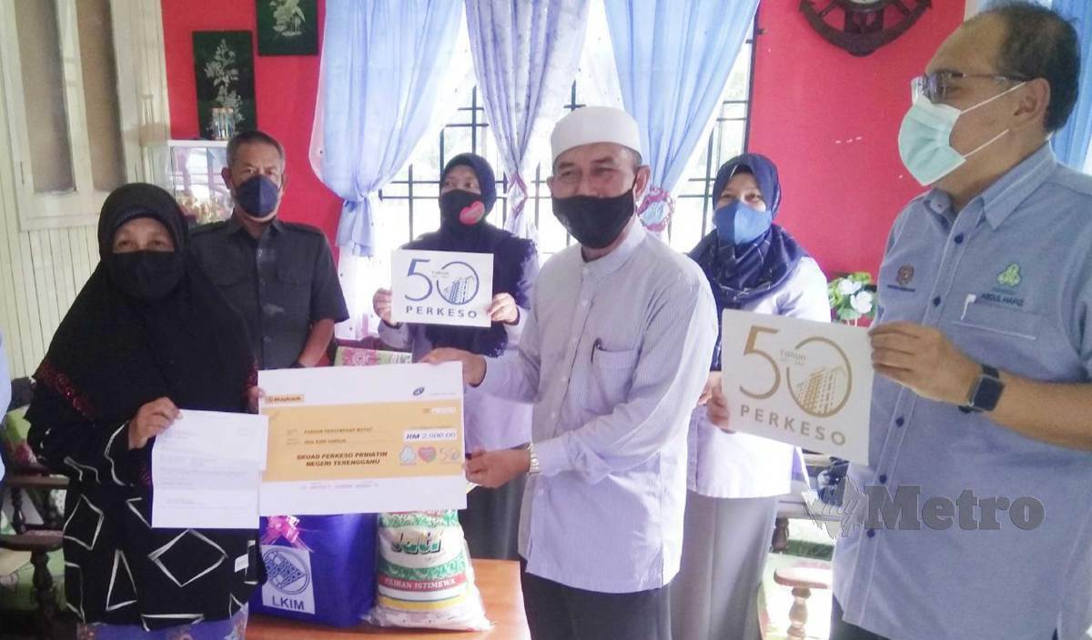 ROHANI (kiri) menerima sumbangan daripada Perkeso dan Lembaga Kemajuan Ikan Malaysia yang disampaikan Ahli Dewan Undangan Negeri DUN Sura, Wan Hapandi Wan Nik. FOTO Rosli Ilham