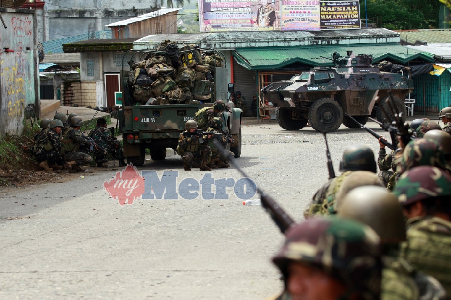 Tentera FilIpina bergerak dengan berhati-hati di laluan sempit antara bangunan di Marawi. - Foto EPA