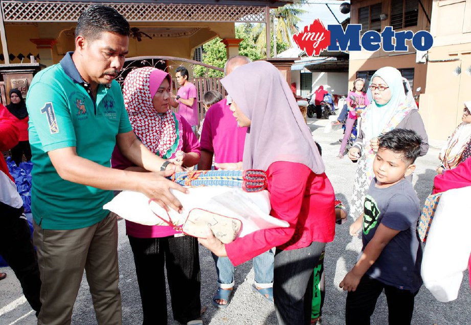 Ketua UMNO Bahagian Permatang Pauh, Datuk Mohd Zaidi Mohd Said (kiri) menyampaikan bantuan kepada sebahagian 100 mangsa banjir di Kampung Penanti, Bukit Mertajam, Pulau Pinang. FOTO AMIR IRSYAD OMAR