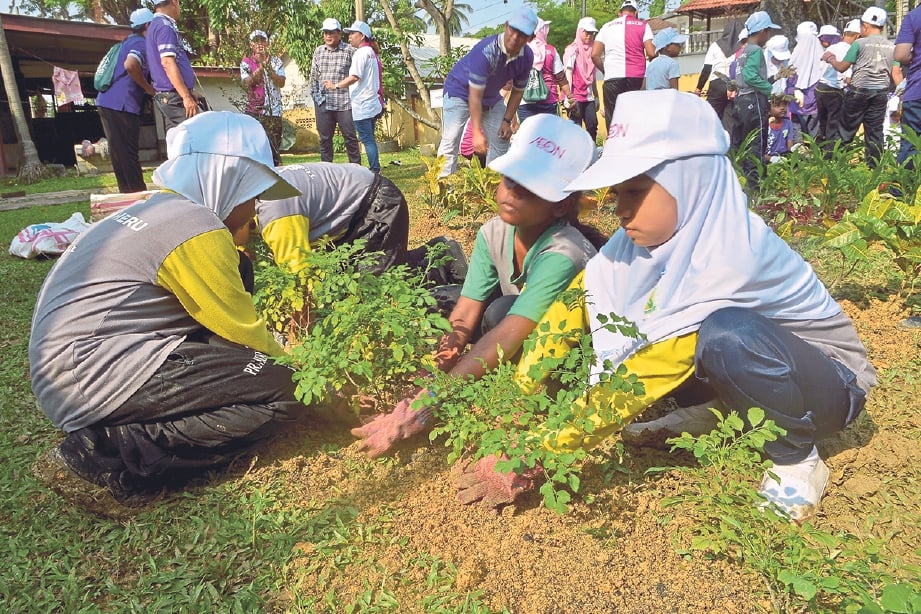 Sukarelawan AEON serta murid menyertai aktiviti menanam pokok pada Program AEON Clean & Green di Sekolah Kebangsaan 1 Jalan Meru, Klang. -Foto FAIZ ANUAR 