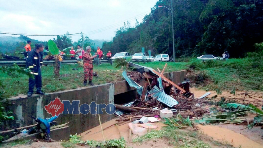 ANGGOTA bomba meninjau lokasi dua wanita berpaut pada pokok selepas rumah mereka dihanyutkan arus deras akibat kepala air di Kampung Batu 60, Jalan Bambangan, Beaufort, petang ini. FOTO ihsan bomba