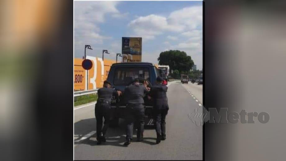 ANGGOTA polis membantu menolak kereta rosak. FOTO ihsan pembaca