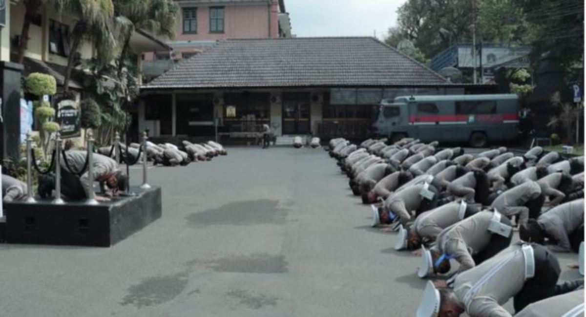KIRA-KIRA 100 anggota Polis Kota Malang dipimpin Ketuanya, Budi Hermanto secara spontan bersujud beramai-ramai. FOTO Agensi 