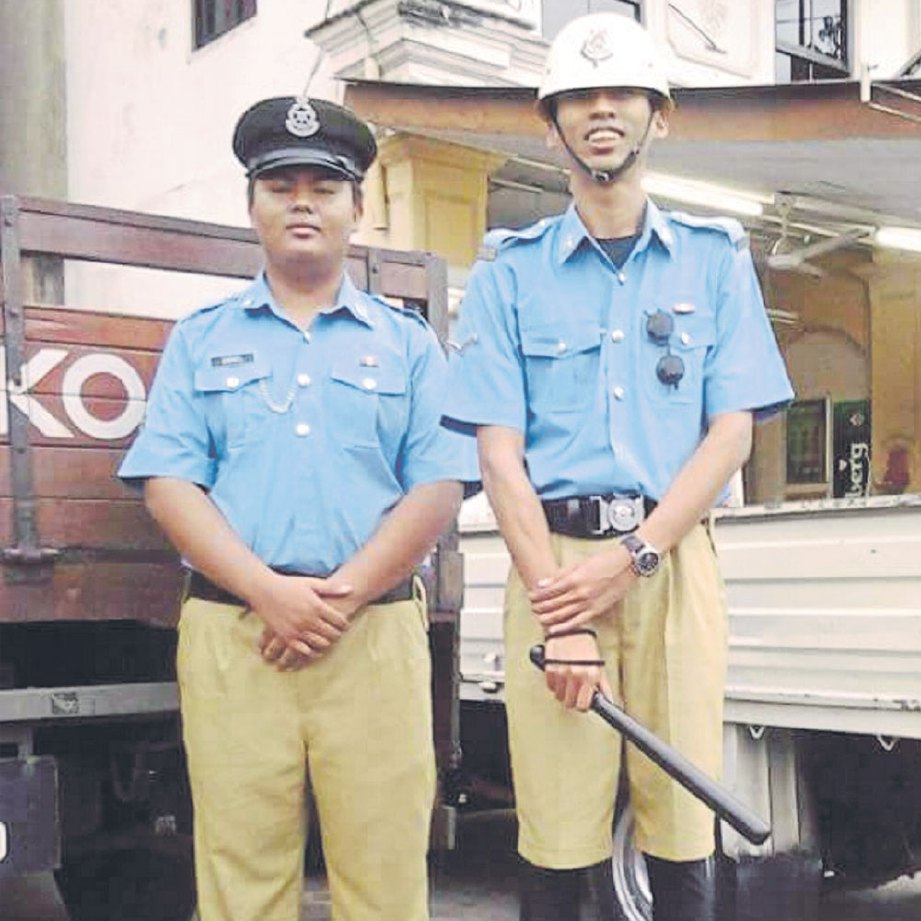 DANIEL (kiri) bersama abangnya menggayakan pakaian seragam polis.