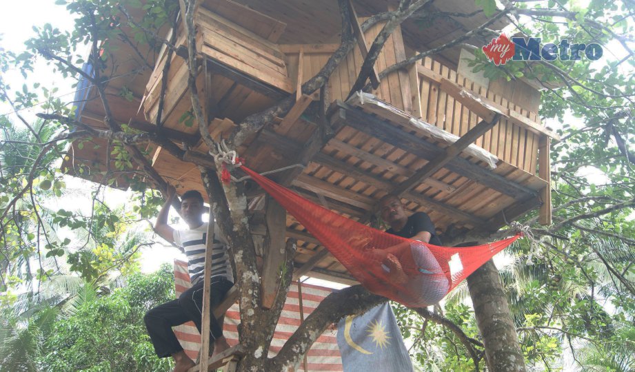 IMRAN  (kanan) dan anaknya berehat dalam pondok atas pokok limau yang dibinanya. FOTO Sabaruddin Abd Ghani