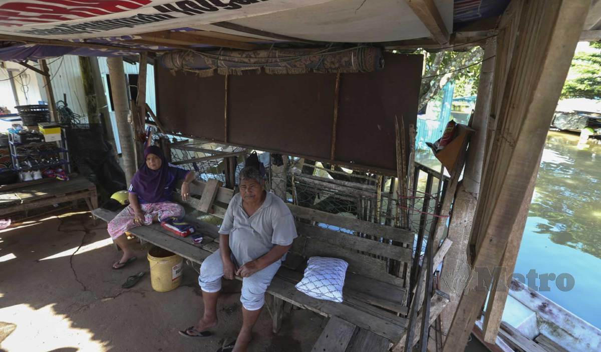 JASMI dan isterinya Wan Kamilah serta tiga anak tidur di pondok yang terletak di hadapan rumah selepas kediaman mereka dinaiki air di Kampung Lubok Gong. FOTO Nik Abdullah Nik Omar