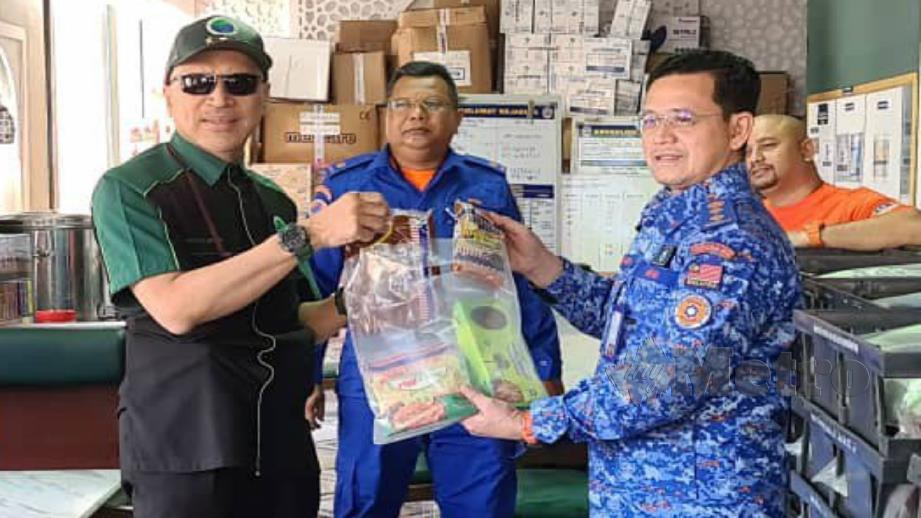 Nadzim menyerahkan sumbangan pek makanan kepada anggota APM di Kuala Lumpur hari ini. Foto Ihsan PPIM