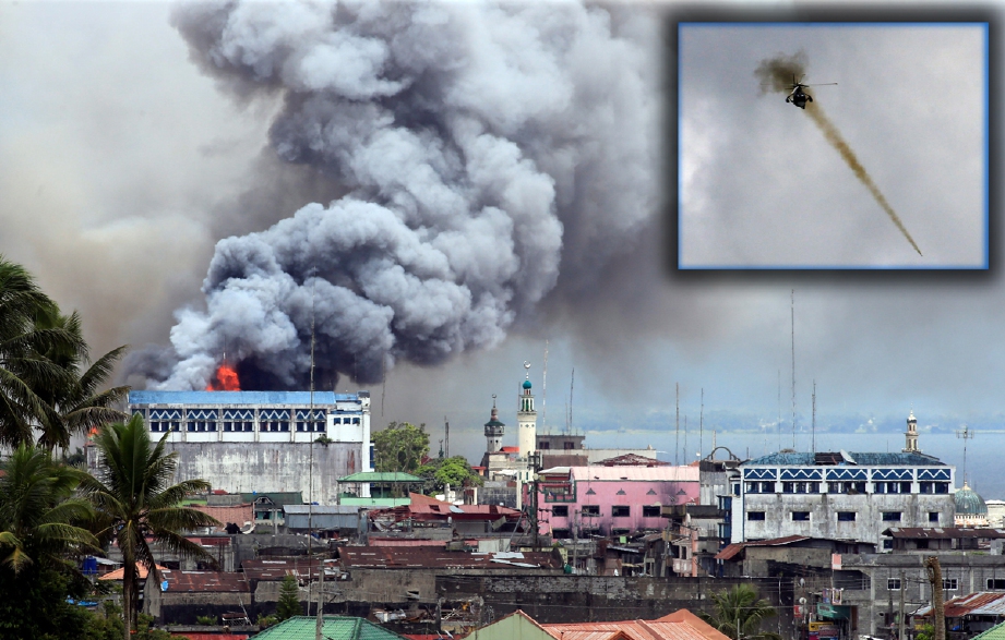 Kepulan asap dari bangunan yang terbakar di kawasan komersial Osmena di Marawi, selepas dibedil tentera. - Foto REUTERS