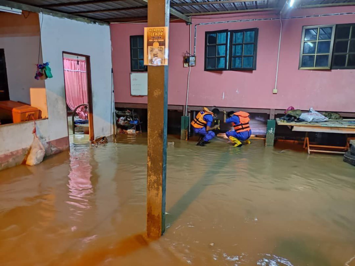 ANGGOTA APM melakukan pemantauan di kawasan rumah yang terjejas akibat banjir. FOTO Ihsan APM