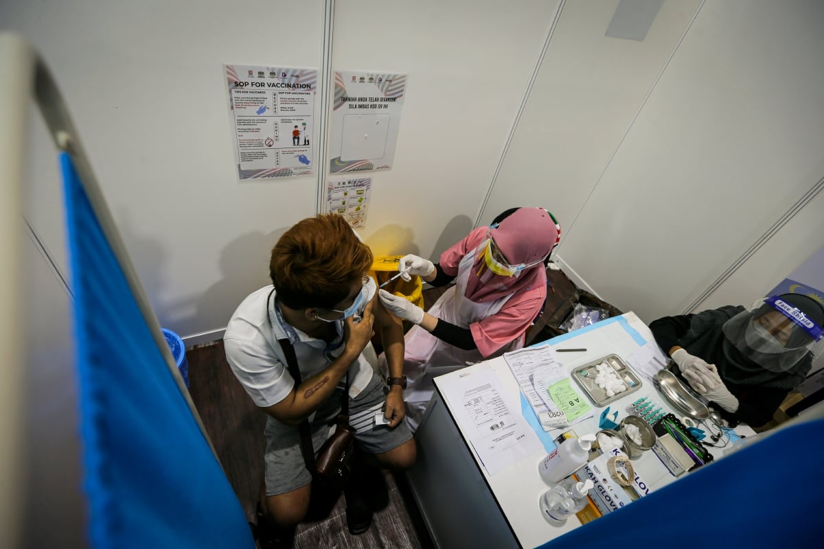 PENERIMA vaksin warga asing menerima suntikan secara ‘walk-in’ di Pusat Pemberian Vaksin (PPV) Stadium Nasional Bukit Jalil. FOTO Aswadi Alias.