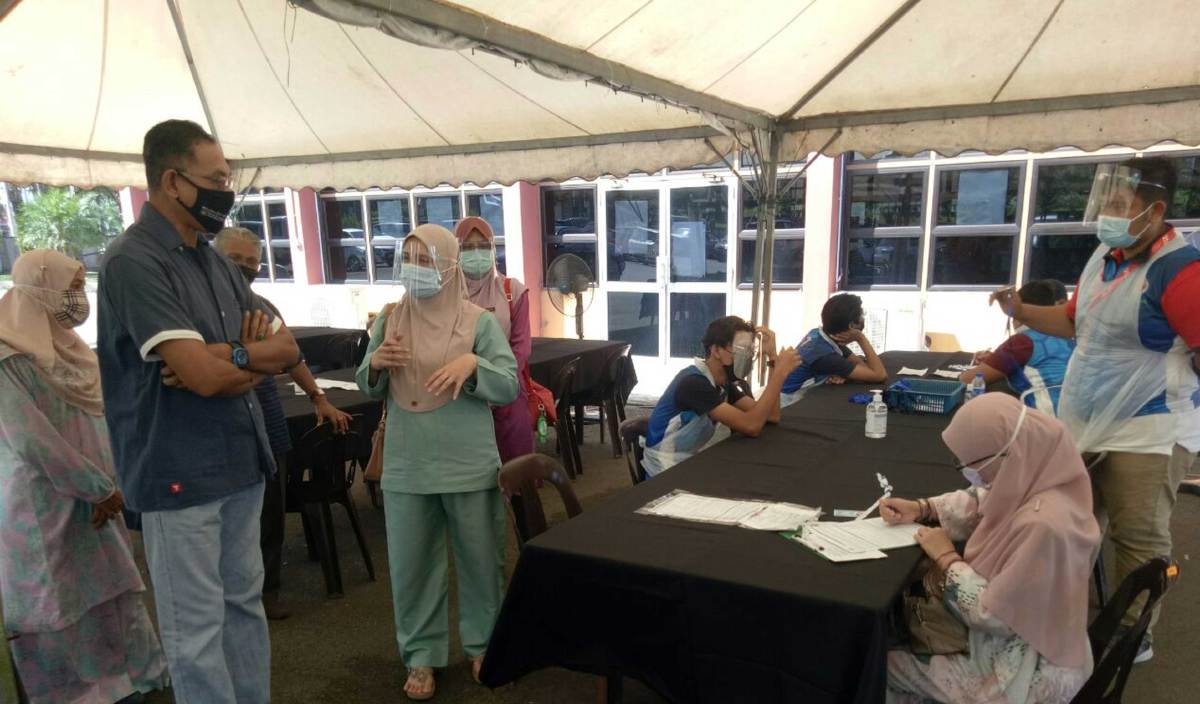 ROSOL (kiri) mendengar taklimat operasi disampaikan Dr Nur Fauzani (dua kanan) ketika melawat Pusat Suntikan Vaksin COVID-19, di Dewan Sivik Ajil. FOTO Baharom Bakar