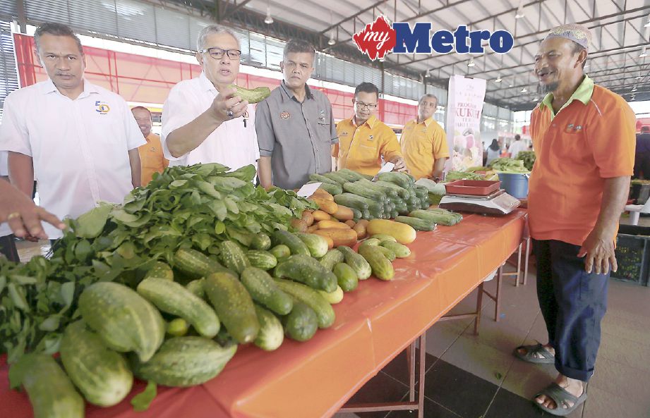 Badruddin (dua kiri) melihat pelbagai sayur-sayuran yang dijual sempena Karnival Khas Pra Syawal di Pasar Komuniti dan Karavan (PAKAR) Jalan Kuala Kedah. FOTO Sharul Hafiz Zam