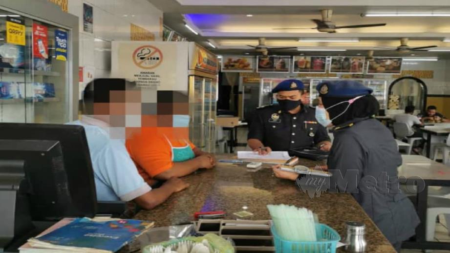 Pegawai KPDNHEP mengambil keterangan pekerja premis makanan di Manjung yang menggunakan ayat al-Quran sebagai representasi takrif halal hari ini. Foto Ihsna KPDNHEP