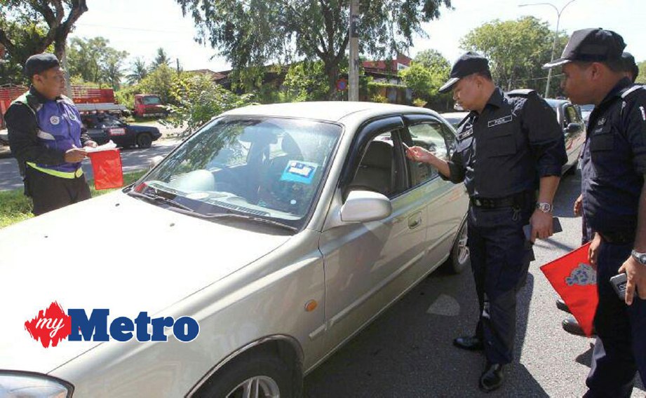 Ketua Jabatan Siasatan dan Penguatkuasaan Trafik Ibu Pejabat Polis Kontinjen (IPK) Kedah, Superintendan Zahari Mohamed (dua kanan) memeriksa lesen memandu pada Operasi Warta di Kilometer 1 Jalan Alor Setar-Butterworth. FOTO SHARUL HAFIZ ZAM