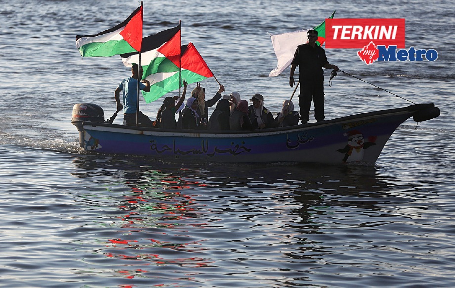 Wanita Palestin menaiki bot sambil mengibarkan bendera tanda sokongan kepada kapal  Women's Boat to Gaza (WBG) yang ditawan tentera Israel. - Foto EPA
