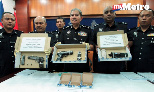 Ketua Polis Kelantan Datuk Mazlan Lazim (tengah) bersama Timbalannya Senior Asisten Komisioner Ab Rashid Ab Wahab (dua dari kiri) menunjukkan dua pistol yang dirampas. - Foto SYAMSI SUHAIMI