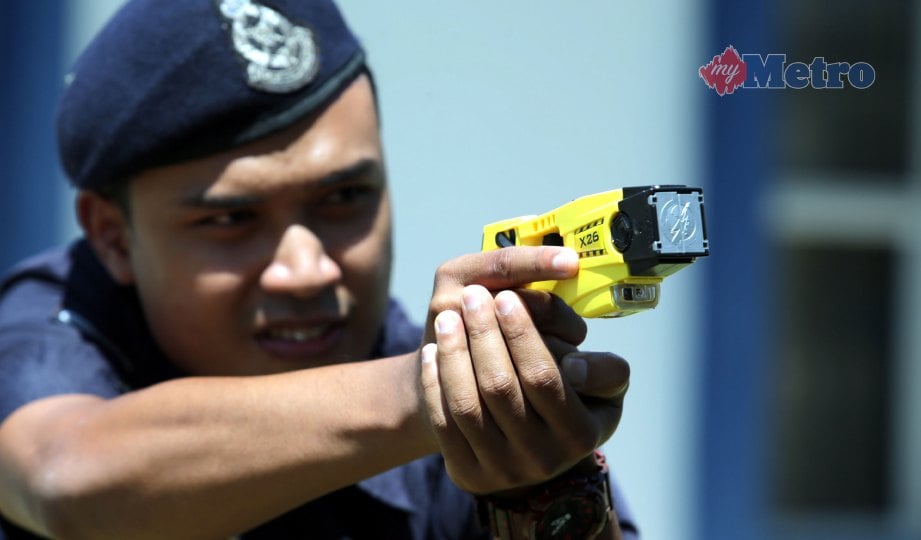 ANGGOTA polis mencuba taser gun.  FOTO Zulkepli Osman