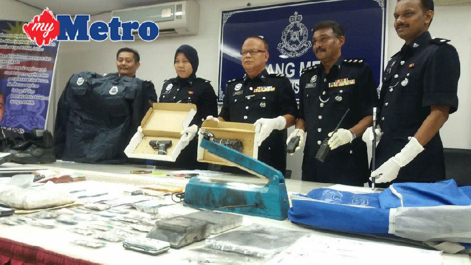 Abdullah (tengah) menunjukkan dua pistol tiruan serta pelbagai barangan termasuk dadah dan wang tunai yang dirampas dalam serbuan di premis di Jalan Lebuh Bandar 1 Bandar Putra, Kulim. FOTO Azahar Hashim