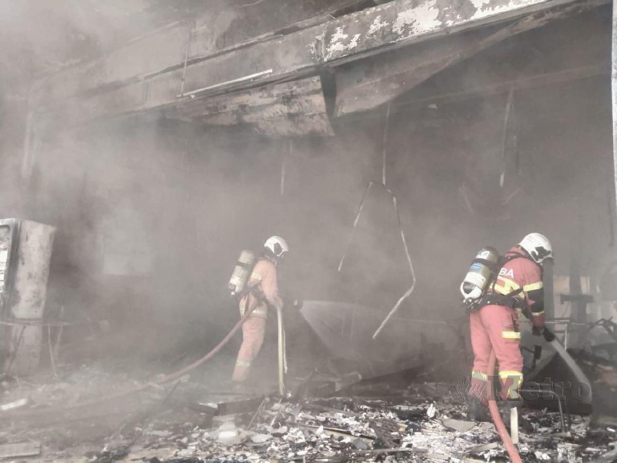 ANGGOTA bomba memadamkan kebakaran sebuah bengkel di Bukit Puchong, Puchong, hari ini. FOTO ihsan bomba