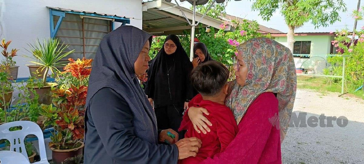Nurul Hazirah (kanan) dan ibu mentuanya memujuk Muhammad Aidan Faaeq yang menangis kerana mahu menziarahi kubur bapanya. Foto Meor Riduwan Meor Ahmad