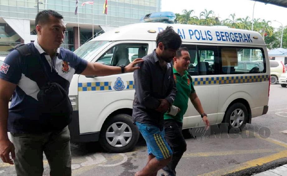 ANGGOTA polis mengiring suspek yang disyaki memukul pemandu e-hailing. FOTO ihsan polis 