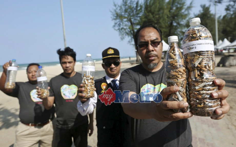 Harmy (kanan) menunjukkan puntung rokok yang dikutip sempena Kempen Masyarakat Sejahtera Tanpa Asap Rokok di Pantai Batu Buruk. FOTO Ghazali Kori 