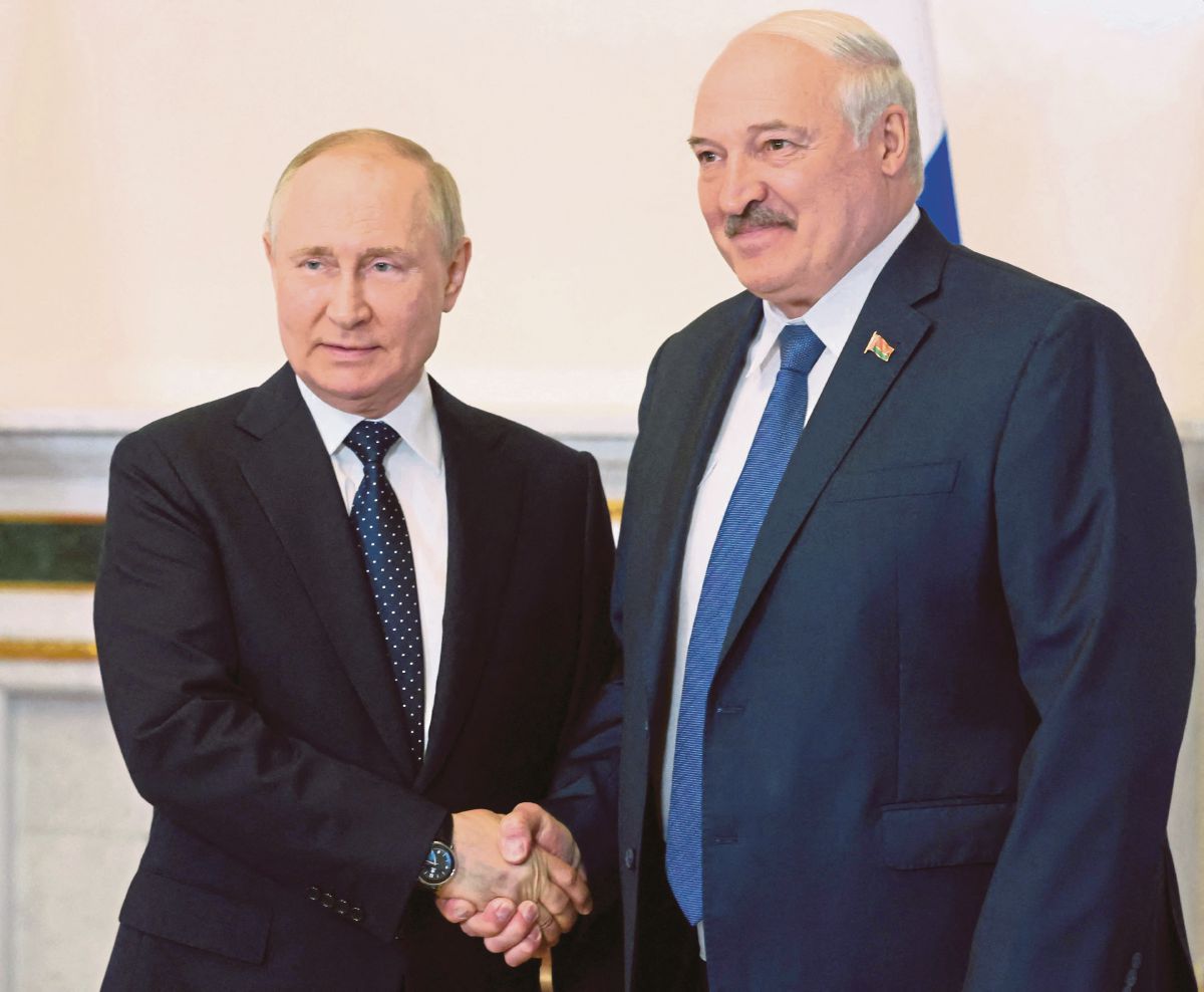 PUTIN (kiri) berjabat tangan dengan Alexander Lukashenko ketika pertemuan Saint Petersburg, Rusia. FOTO AFP 